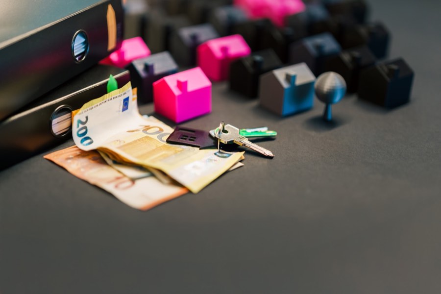 Model domu s klíči a financemi.